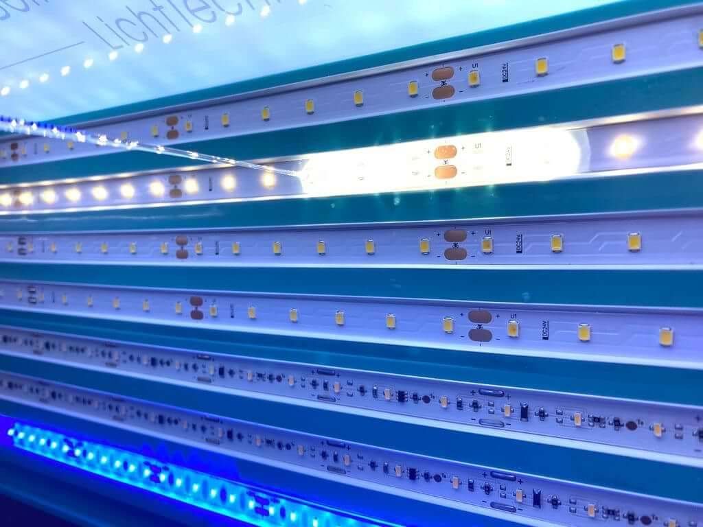 Blau beleuchtete LED-Streifen, auf denen verschiedene Dioden und Bauteile zu sehen sind.
